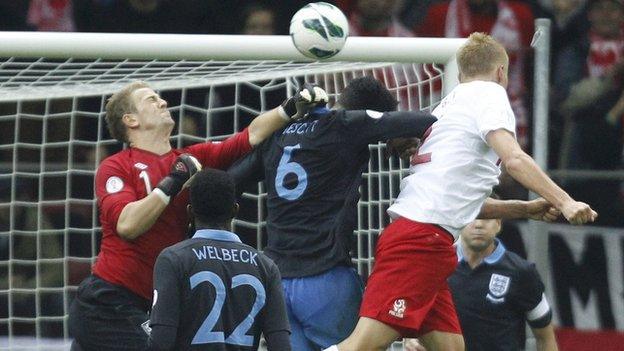 England keeper Joe Hart (left) misses punching out a corner and Kamil Glik (right) heads in for Poland