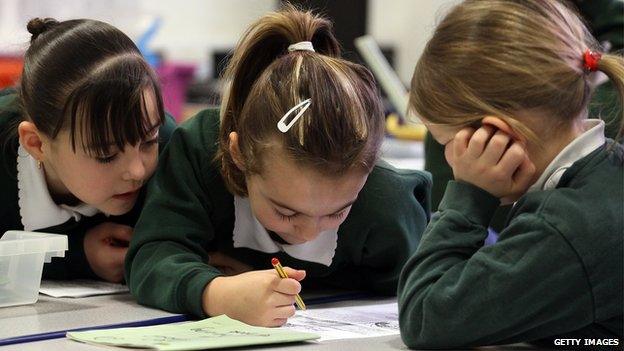 Three primary school girls working at a desk