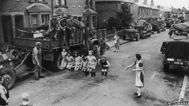 A US soldier helps British children with their skipping