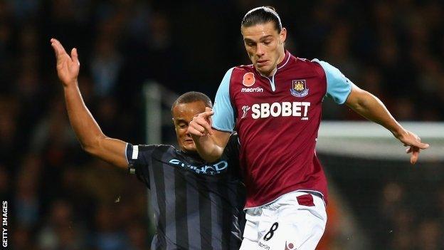 Vincent Kompany challenges West Ham striker Andy Carroll