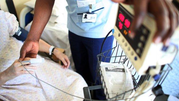 A nurse takes a patients temperature