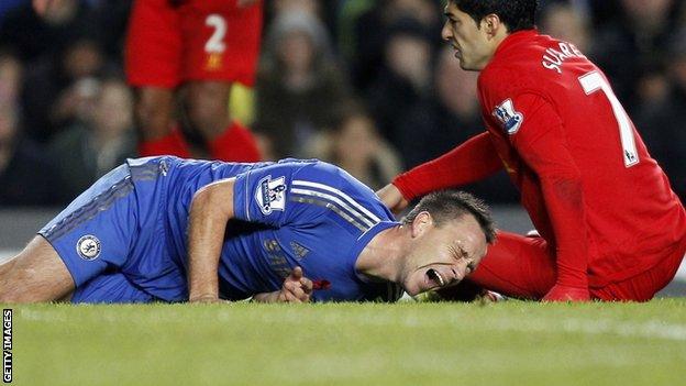 John Terry (left) shows his agony after an accidental collision with Luis Suarez