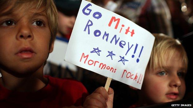 Two children at a Mitt Romney rally in South Carolina, holding up a sign that says "Go Mitt Romney: Mormons rock"