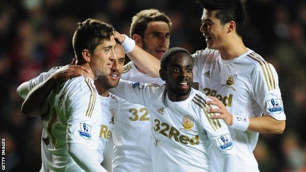 Swansea celebrate their third goal against West Brom