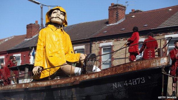 A giant Marionette is towed through Liverpool