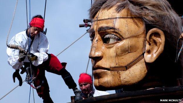 Dozens of people work the ropes of "The Giants" to operate them.