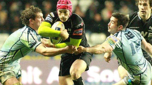 Opsreys try-scorer Richard Fussell takes on Blues' Rory Watts-Jones and Dafydd Hewitt