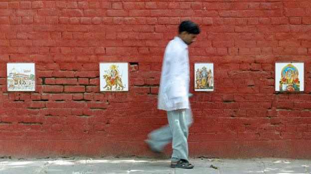 Images of Hindu gods protect a wall from urinaters