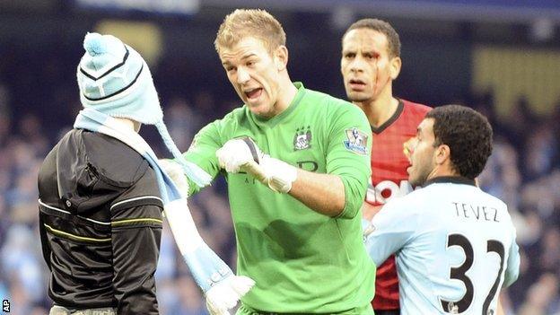 Matthew Stott (left) is stopped from reaching Rio Ferdinand by Joe Hart