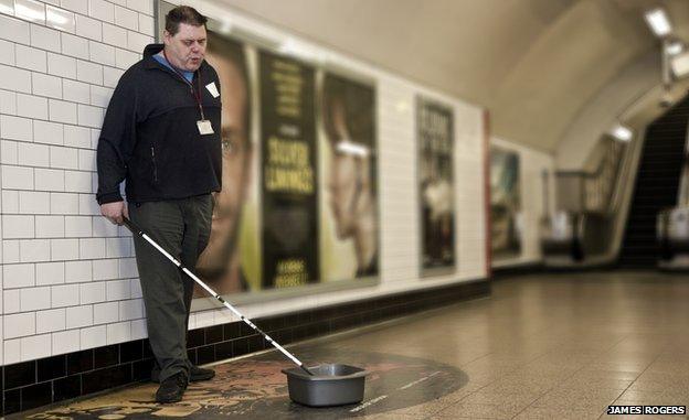 Mark Campbell busking with his cane and washing up bowl