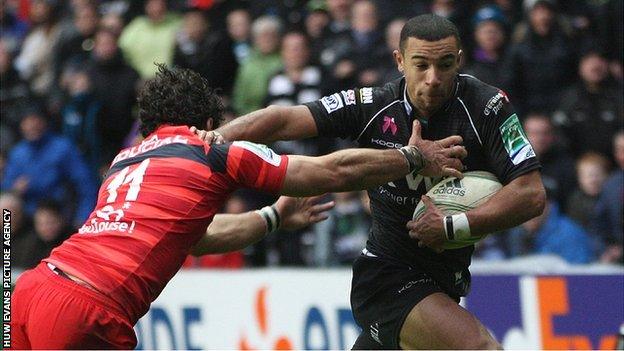 Ospreys wing hands off Yoann Huget of Toulouse to score