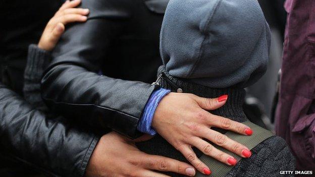 Parents comfort a child in Newtown, Connecticut