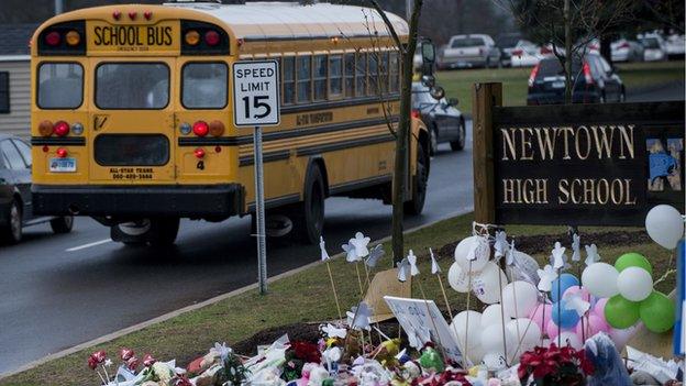 School bus drives past Newtown High School sign