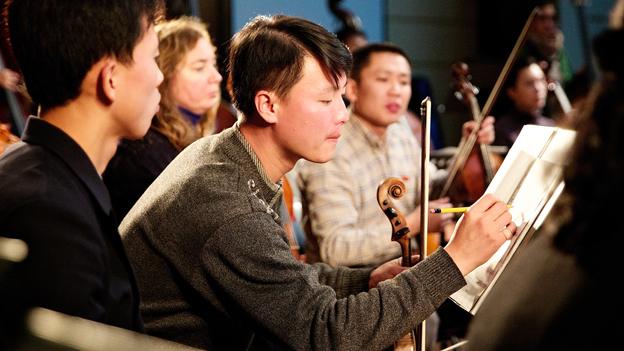 North Korean musician marking up his music sheet