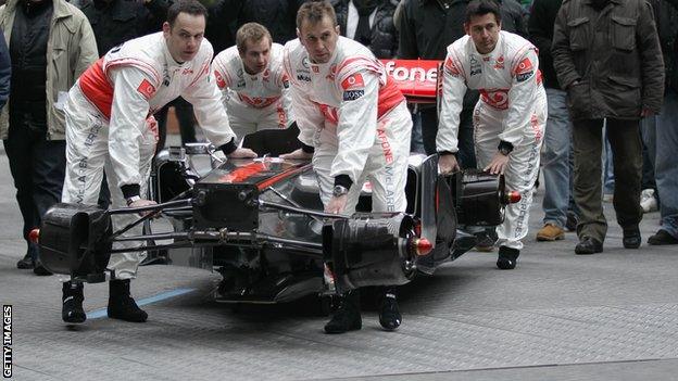 Mclaren mechanics carry the chassis of the McLaren Mercedes MP4-26