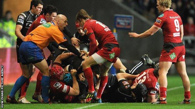 Ospreys and Scarlets players exchange blows