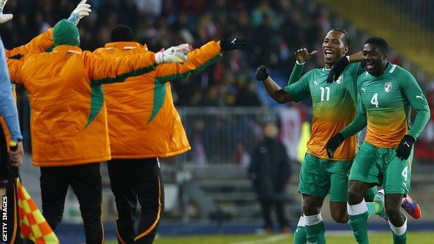 Kolo Toure (R) celebrates with Didier Drogba and team-mates during Ivory Coast's friendly match with Austria in November 2012