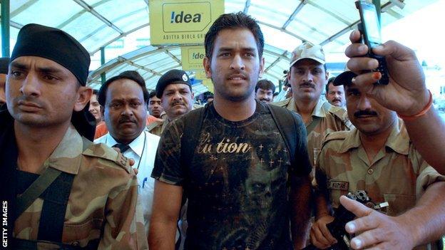 Mahendra Dhoni flanked by guards