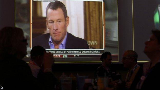 People watch the TV broadcast of Lance Armstrong being interviewed by Oprah Winfrey