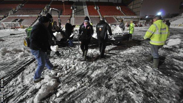 Volunteers help clear the snow at Swindon Town's County Ground