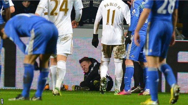 A Swansea ballboy lies on the ground after an altercation with Chelsea midfielder Eden Hazard, who was sent off for his part in the scuffle