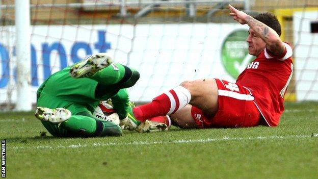 Leyton Orient's Charlie MacDonald slides in on Notts County goalkeeper Bartosz Bialkowski