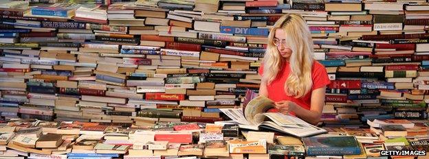 Woman reader among stacks of books at the Southbank Centre, London