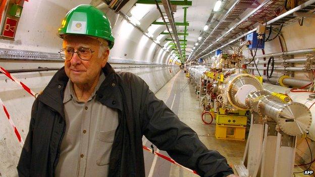 Prof Peter Higgs stands proudly beside the Large Hadron Collider