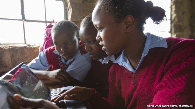 Students examine a laptop