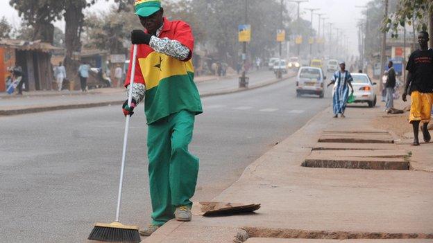 A street cleaner - wearing Ghanaian football colours - in Kumasi in 2008