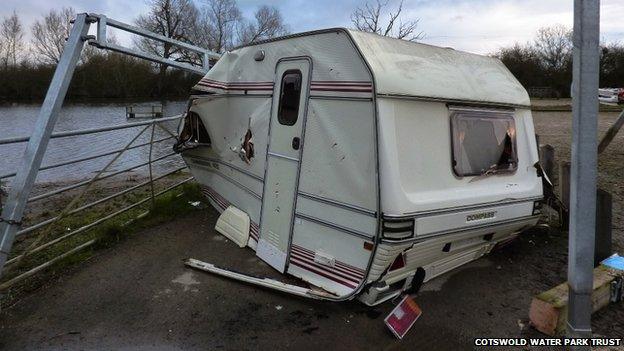 A caravan, filled with household waste, is dumped and demolished at Waterhay car park, part of Cotswold Water Park