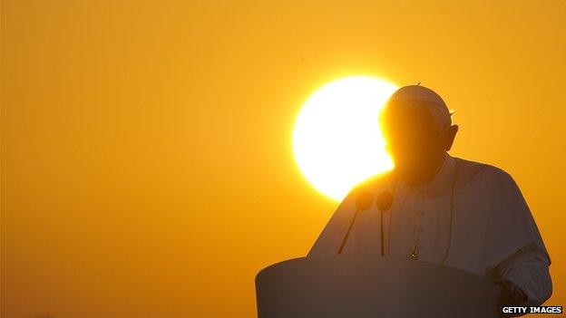Pope preaching against background of sunset