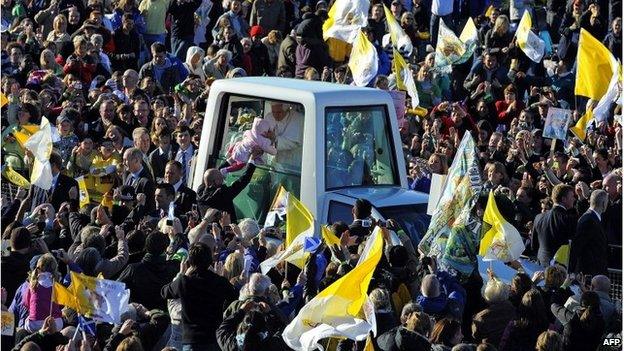 Pope Benedict XVI kisses a baby while at an open-air Mass in Poland, 2010
