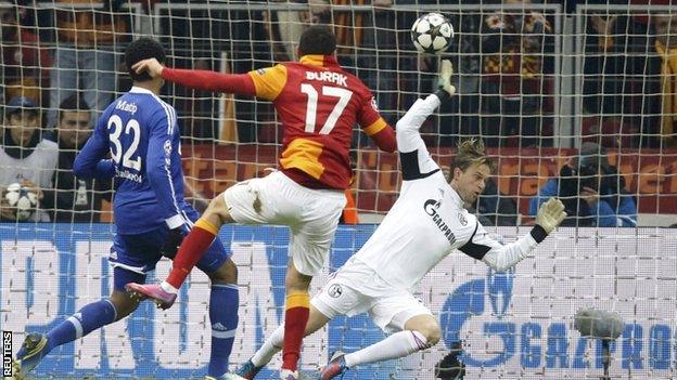 Galatasaray's Burak Yilmaz (c) scores past by Schalke 04's goalkeeper Timo Hildebrand