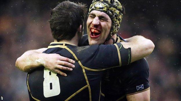 Bloodied Scotland captain Kelly Brown hugs number eight Johnnie Beattie after their bruising win at home to Ireland