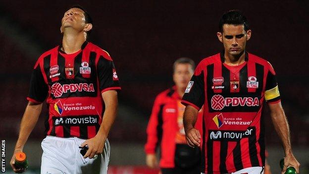 Deportivo Lara players Miguel Mea Vitali (R) and Marcelo Maidana after their Copa Libertadores defeat by Chile's Universidad de Chile