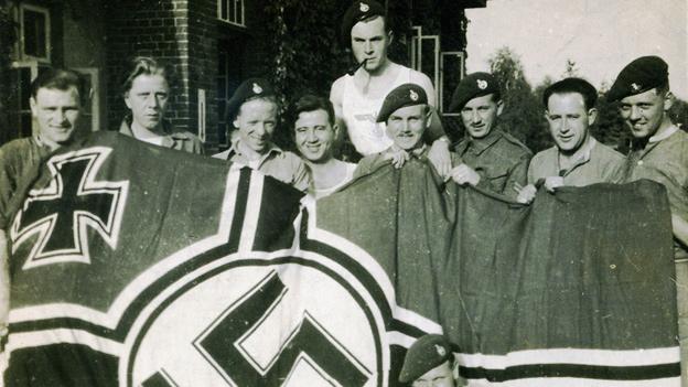 30AU posing with a captured German flag (photos from Nick Rankin's book Ian Fleming's Commandos)