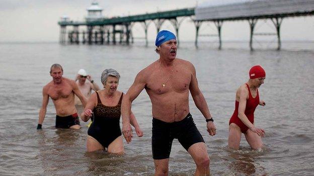 Swimmers leave the water next to Clevedon Pier.