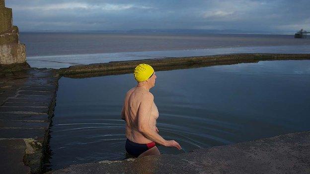 A swimmer looks out to sea