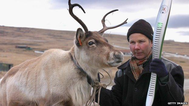 Mike Butcher with his reindeer 'Gordy' with the 2006 baton in the Falkland Islands