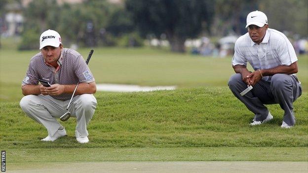 Graeme McDowell and Tiger Woods assess the green in Miami