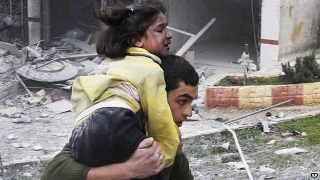 Syrian man carries his sister who was wounded in an airstrike in Aleppo, Syria, Sunday 3 February 2013