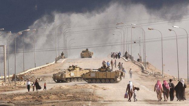 Civilians cross a bridge near Basra, in March 2003