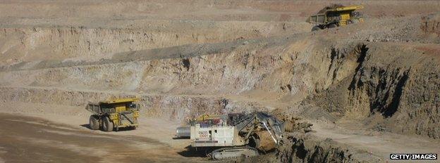 A digger and two ore trucks at the Oyu Tolgoi mine in Mongolia