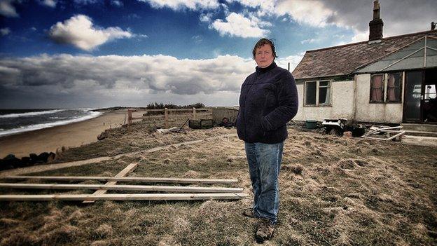 Bryony Nierop-Reading stands on the cliff edge next to her Happisburgh home