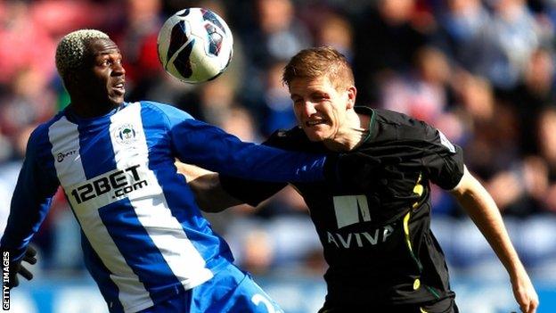 Arouna Kone (left) of Wigan in action with Michael Turner of Norwich