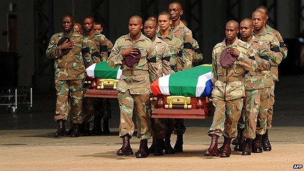 South African soldiers carry the coffins of their colleagues who died during a battle with rebels in the Central African Republic at Waterkloof Air Force Base in Pretoria on 28 March 2013