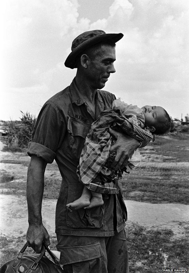 Staff Sergeant Edgar D Bledsoe, of Olive Branch, Illinois, cradles a critically ill Vietnamese infant