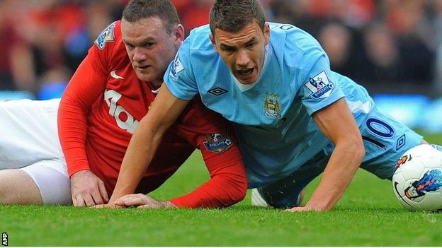 Wayne Rooney (left) challenges Edin Dzeko