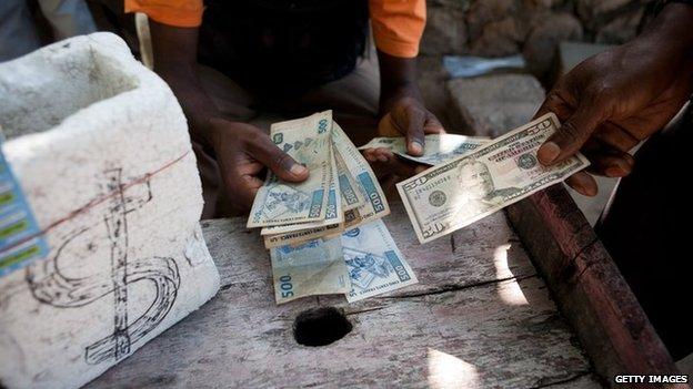 A man changes a 50 USD bank note for Congolese Francs with a money changer in the street of Kinshasa.